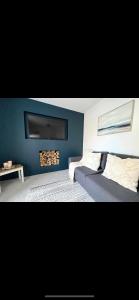 a bedroom with a blue wall with a fire place at Homely and Deceptively large city house in Swansea