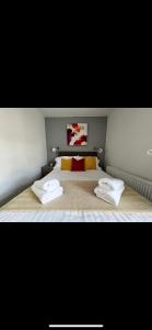 1 dormitorio con 1 cama con 2 toallas en Homely and Deceptively large city house, en Swansea