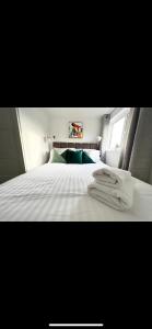 a bedroom with a bed with white sheets and a window at Homely and Deceptively large city house in Swansea