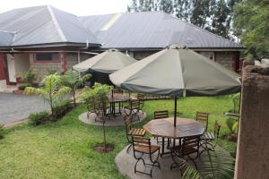 a group of tables and chairs under an umbrella at Good Morning Hotel Rongo in Paulo
