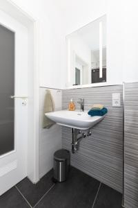 a bathroom with a white sink and a mirror at Ferienwohnung de Vries in Langeoog