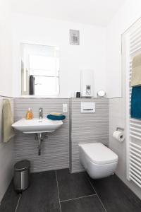 a bathroom with a sink and a toilet at Ferienwohnung de Vries in Langeoog