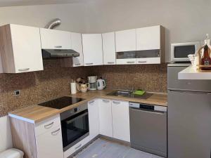 a kitchen with white cabinets and stainless steel appliances at Apartment in Bribir 15452 in Bribir