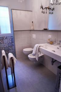 a white bathroom with a toilet and a sink at Corte Cantoni in Nonantola