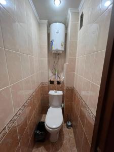 a small bathroom with a toilet and a water tank at Стандарт Камзина 74 г. Павлодар in Pavlodar