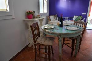 a dining room table with chairs and a bottle of wine at Corte Cantoni in Nonantola