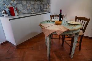 a table in a kitchen with a bottle of wine at Corte Cantoni in Nonantola