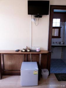een kamer met een bureau, een televisie en een doos bij PP Natural Hill in Phi Phi Don