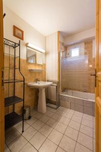 a bathroom with a sink and a shower and a tub at Fleurs et Neige in Lanslevillard