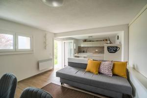 ein Wohnzimmer mit einem grauen Sofa und gelben Kissen in der Unterkunft Ales Green in Camorino