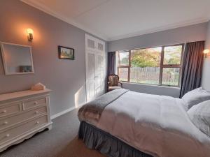 - une chambre avec un lit, une commode et une fenêtre dans l'établissement Wonderful Woodlands Estate, 