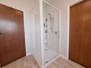 La salle de bains est pourvue d'une douche avec une porte en verre. dans l'établissement Wonderful Woodlands Estate, 