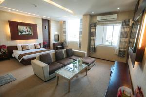 um grande quarto de hotel com uma cama e um sofá em Biet Dien Hotel em Buon Ma Thuot