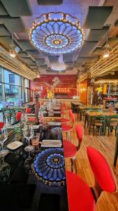 a restaurant with a long bar with red chairs and a chandelier at Radisson Hotel & Suites Zurich in Opfikon +108 photos