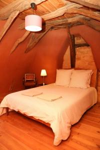 1 dormitorio con 1 cama grande en una cabaña de madera en La Maison de Jardin à La Peyrière, en Le Bugue