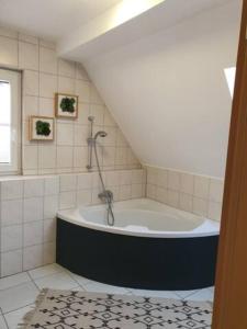 La salle de bains mansardée est pourvue d'une baignoire. dans l'établissement Schöne Wohnungen in Schwandorf, à Schwandorf in Bayern