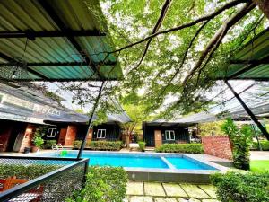 a swimming pool in front of a house at Petak Padin Cottage by The Pool in Kepala Batas