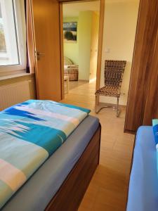 ein Schlafzimmer mit einem Bett und einem Stuhl in der Unterkunft Ferienwohnung mit 2 Schlafzimmern in Zinnowitz