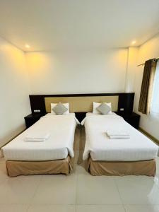 twee bedden naast elkaar in een kamer bij Bualinn Resort in Nong Khai