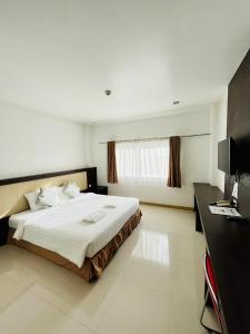 een slaapkamer met een groot bed en een bureau bij Bualinn Resort in Nong Khai