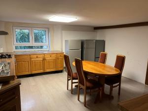 a kitchen with a table and chairs and a refrigerator at Pension Hirsch in Fluorn