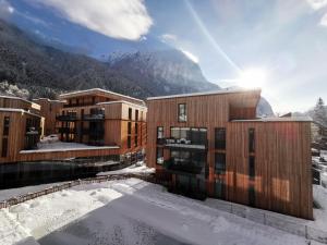 a resort in the snow with a mountain in the background at All-Suite Resort Ötztal in Oetz