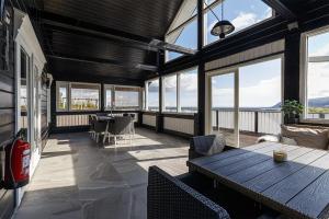 a large room with a table and chairs and windows at Blue Viking Luxury Cabin in Selfoss