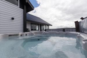 a large swimming pool next to a house at Blue Viking Luxury Cabin in Selfoss