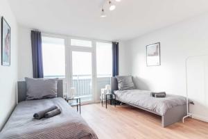 a bedroom with two beds and a large window at Chic City-View Apartments in Hanau in Hanau am Main