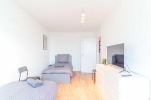 two beds in a room with white walls and wooden floors at Chic City-View Apartments in Hanau in Hanau am Main