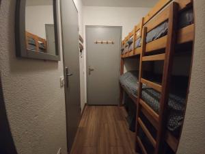 pasillo de una habitación con literas y puerta en studio Loubat pyrénée, ménage inclus, en Arette