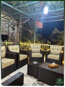 a patio with wicker chairs and a table and lights at AlSalti Farm - مزرعة السلطي in Ajloun