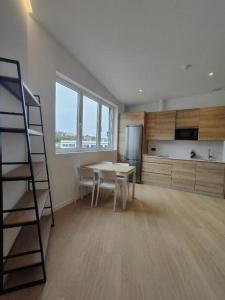 Habitación con mesa y cocina con escalera en Apartamentos Pillotegi parking gratuito, en San Sebastián