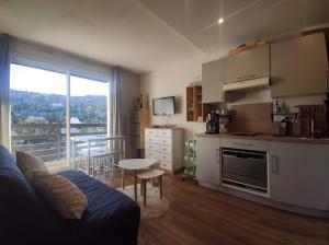 cocina con sofá y mesa en una habitación en studio Loubat pyrénée, ménage inclus, en Arette