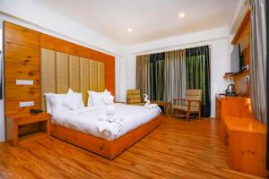 a hotel room with a large bed and a desk at Sky Desert in Leh