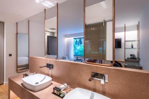a bathroom with a sink and a mirror at Amario Suites Hotel in Aigio