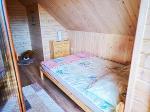 a bedroom with a bed in a wooden cabin at Alma in Rzyki