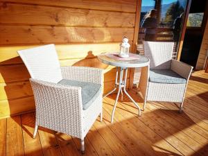 three wicker chairs and a table on a porch at Alma in Rzyki