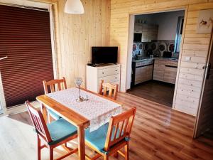 cocina y comedor con mesa y sillas en Alma en Rzyki