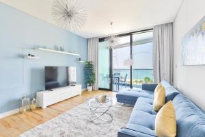 Address Beach Residences في دبي: غرفة معيشة مع أريكة زرقاء وتلفزيون