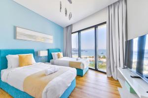 2 camas en una habitación con ventana grande en Address Beach Residences, en Dubái