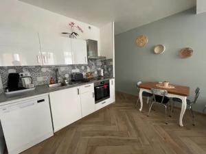 eine Küche mit weißen Schränken und einem Holztisch in der Unterkunft F2 Rez de Chaussée Ô meublé de Pithiviers in Pithiviers