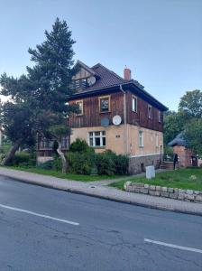 a large wooden house on the side of a road at Apartament Świerkowy in Karpacz