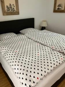 un letto con un piumone bianco e nero sopra di Vazerol a Lenzerheide