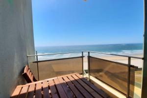 einen Balkon mit einer Holzbank am Strand in der Unterkunft Ondas de Ofir in Fão