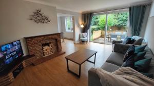 sala de estar con sofá y chimenea en Piping Green 5 bedroom House en Winchester