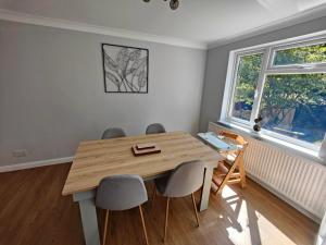 comedor con mesa de madera y sillas en Piping Green 5 bedroom House en Winchester