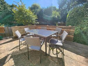 una mesa y sillas en un patio en Piping Green 5 bedroom House en Winchester
