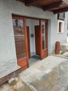 un ingresso a una casa con porta in legno di Residenza L'Teit a Sestriere