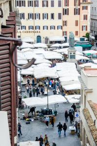 una folla di persone che camminano per un mercato con gli ombrelli di Town House Campo De Fiori a Roma